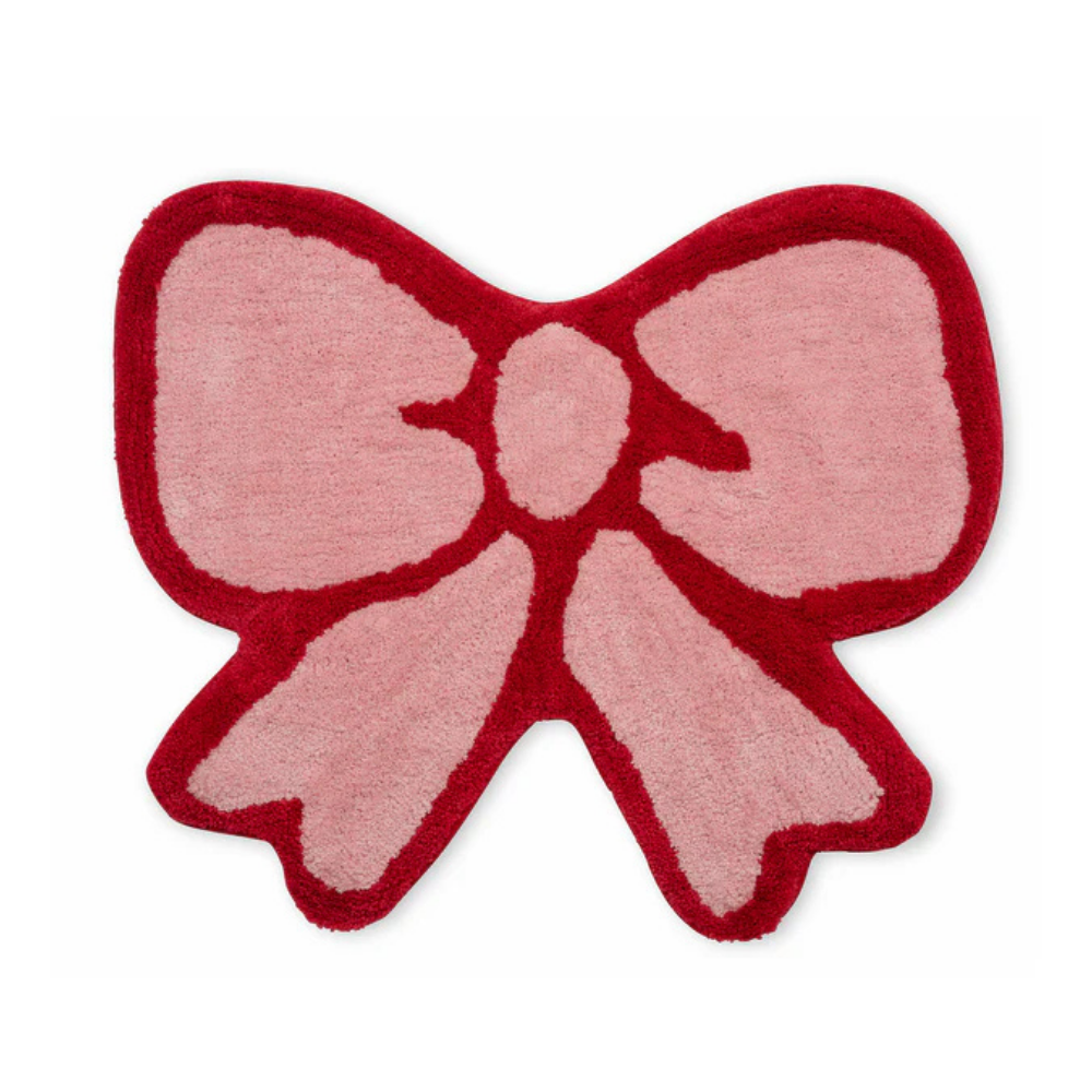 Tappeto Fiocco: a bow-shaped rug in light pink with a bright red border.
