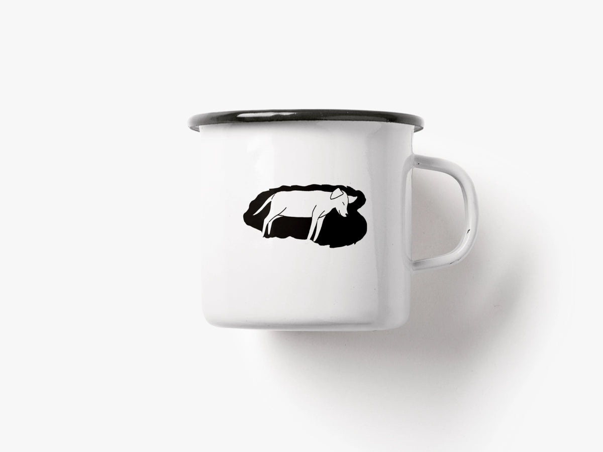 The white enamel mug with a black silhouette of a lying dog printed on the front.