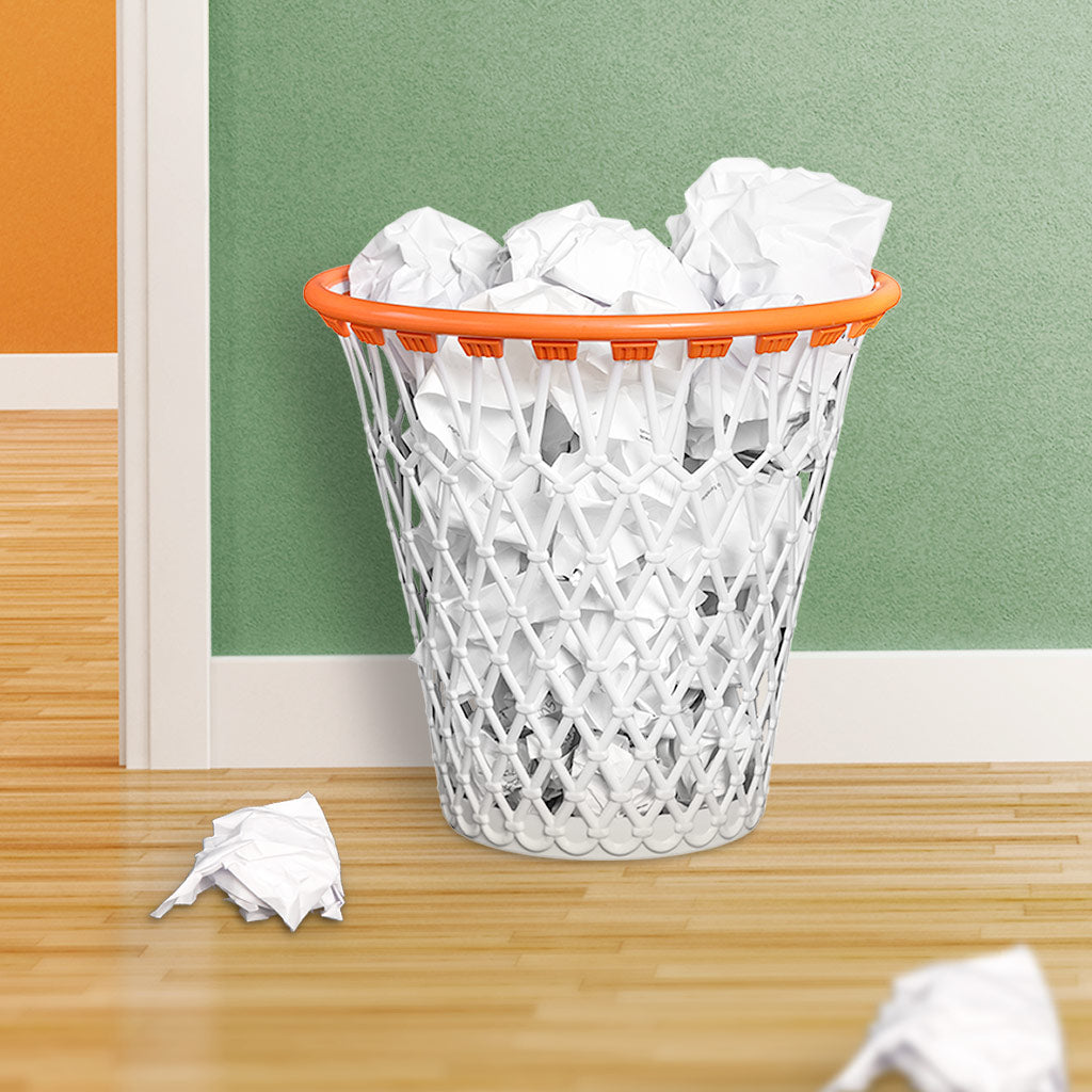 Basket bin filled with crumpled paper balls, standing against a wall
