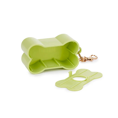 Green Biscuit dog waste bag holder clipped to a leash, with a dog blurred in the background