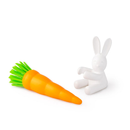 Bunny dish brush lying on a white background next to the rabbit