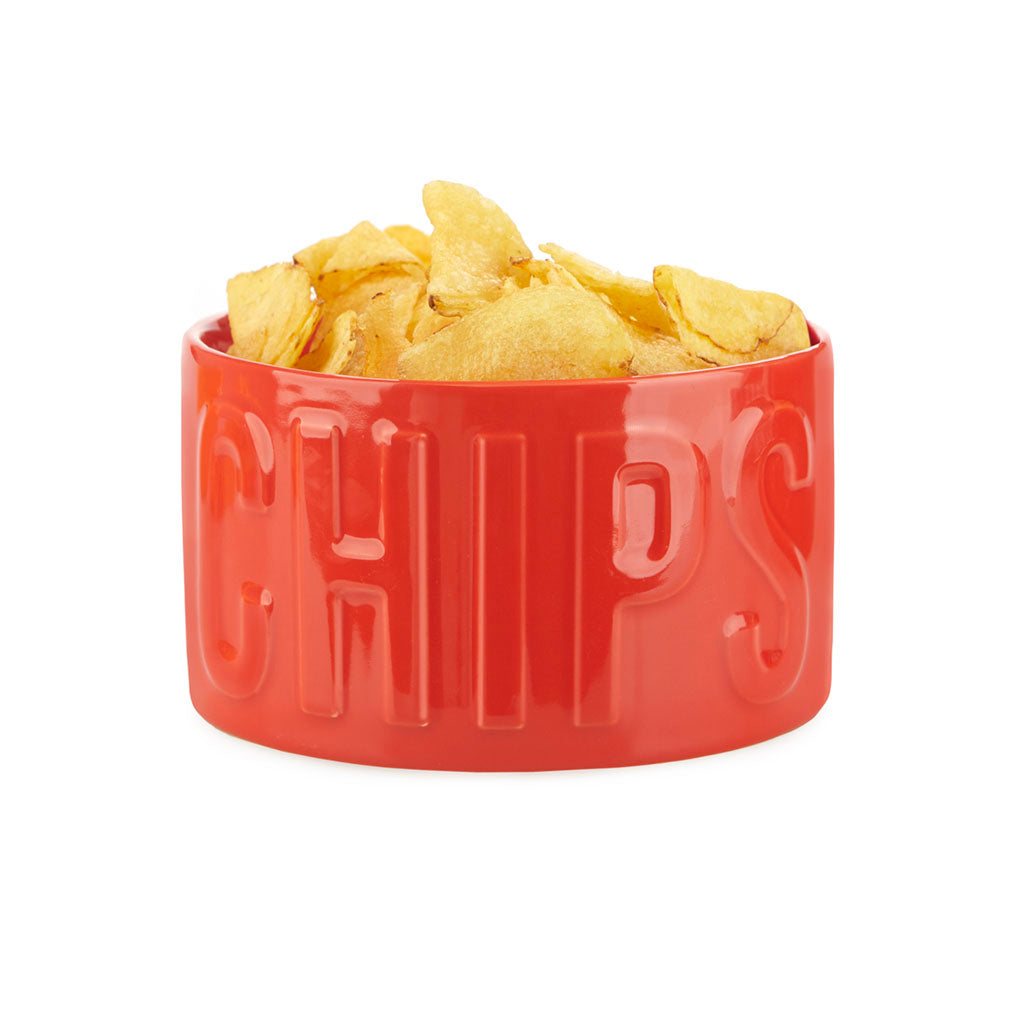 Ciotola rossa con la scritta a rilievo CHIPS, piena di patatine, su sfondo bianco