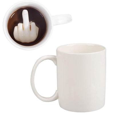Middle Finger mug seen from above with the finger in the coffee, next to an empty white mug.