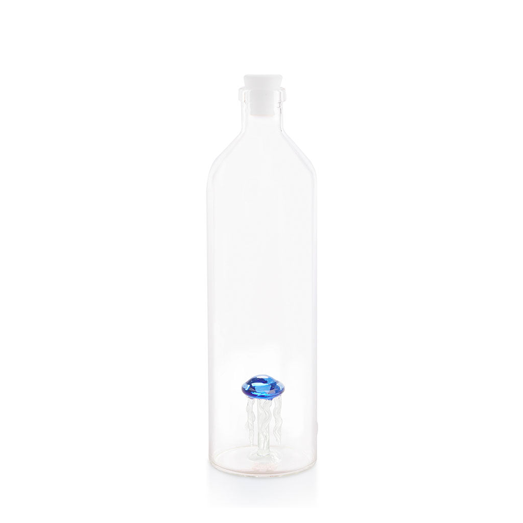 Tall clear bottle with a white stopper and a faceted blue shape at the bottom