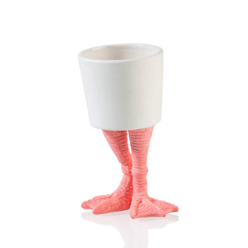 Vaso Fenicottero: a white cup standing on two pink flamingo legs, shown empty.