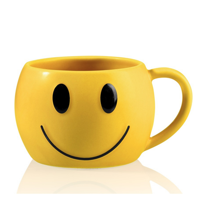 Yellow mug shaped like a smiling face, with black eyes and mouth