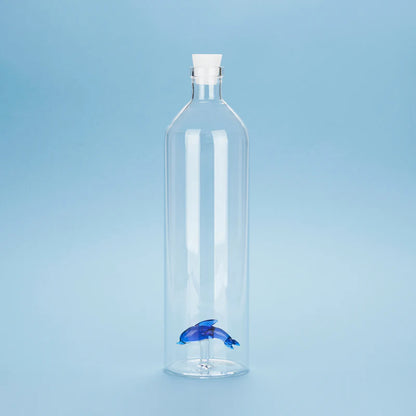 Atlantis Delfino bottle, clear glass with a blue dolphin shape at the base, blue background