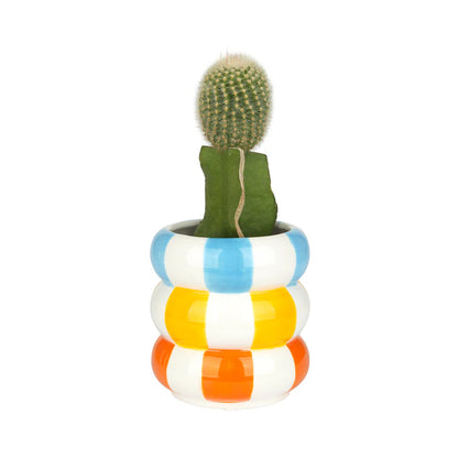 Ceramic pot made of stacked stripes, holding a cactus