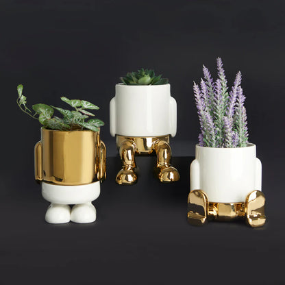 Mr. Sitty Gold mini vase in gold and white shown with two others holding pothos and lavender