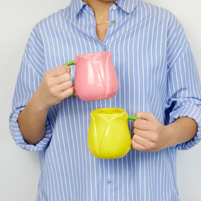 Pink and yellow Tulip mugs held by a person in a striped shirt
