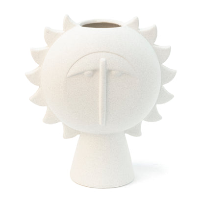 White vase shaped like a radiant face surrounded by spikes, on white