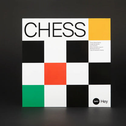 Hey Chess set seen from above, a hand moving a blue piece across the black and white board.