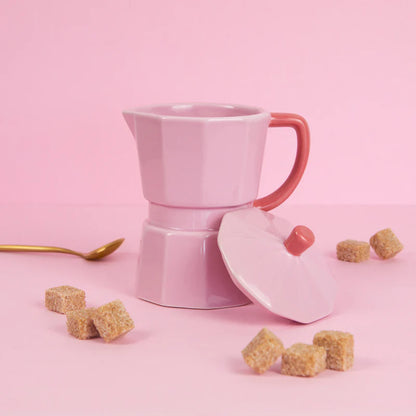 Pink Moka mug with a red handle and brown sugar cubes beside it