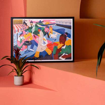 Paris Puzzle framed and leaning against an orange wall, next to a white potted plant.