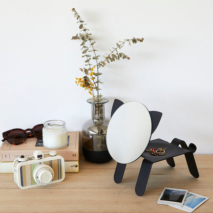 Cat Table Mirror on a shelf among sunglasses, a candle and a camera