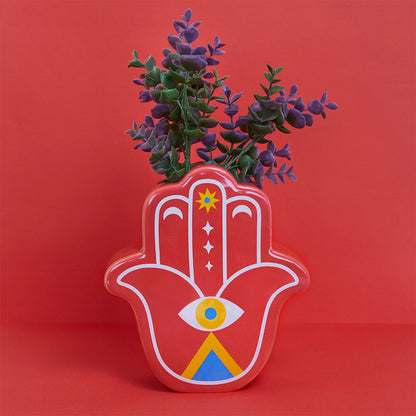 Red Lucky Hand vase with purple leaves on a red background