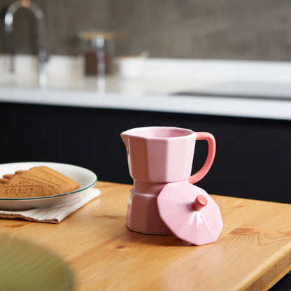 Pink Moka Mug on a wooden table with biscuits, lid resting beside it