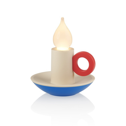 Candle Memphis lamp lit, cream body with a red ring handle and a blue saucer base.