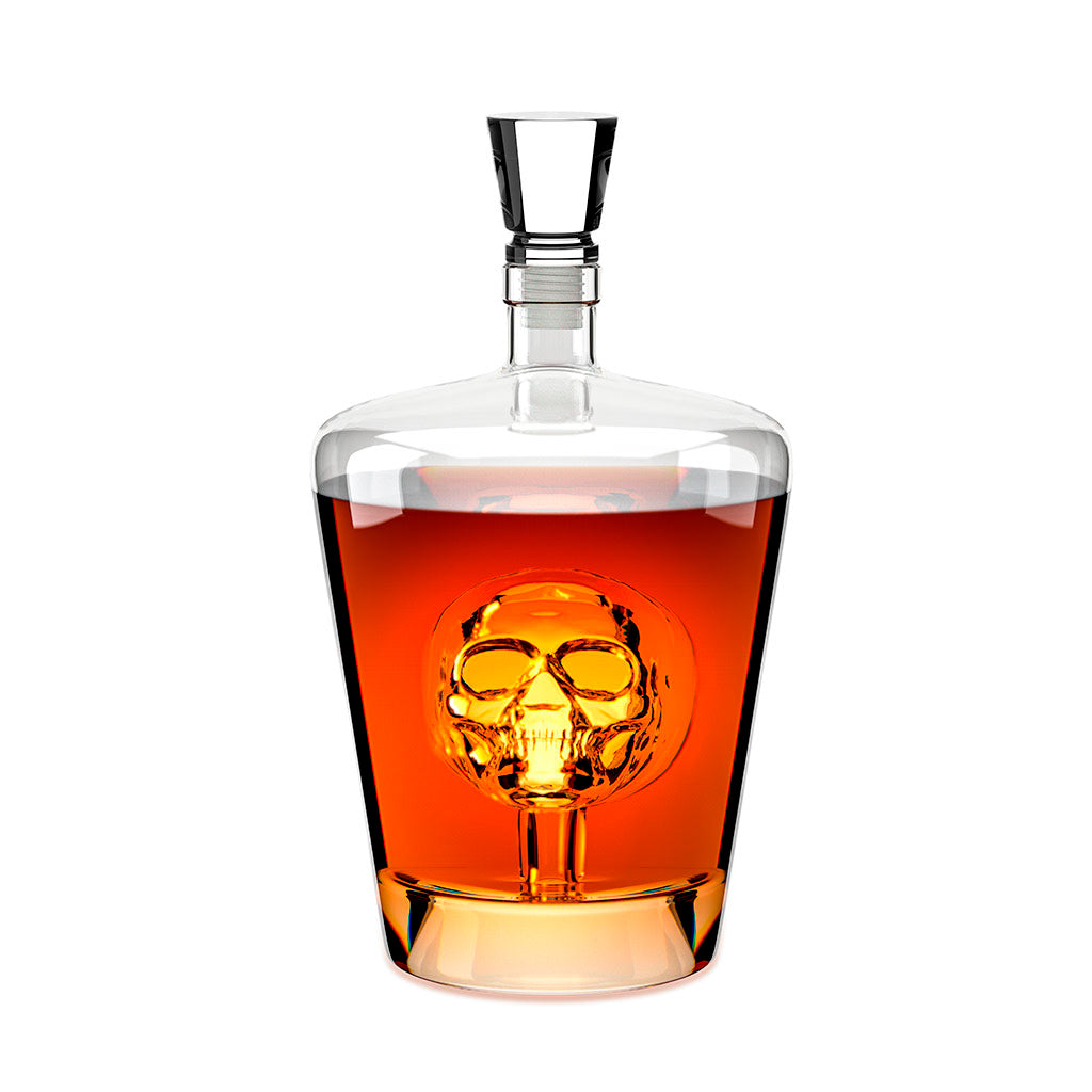 Clear glass decanter with a stopper and a glass skull inside amber liquid