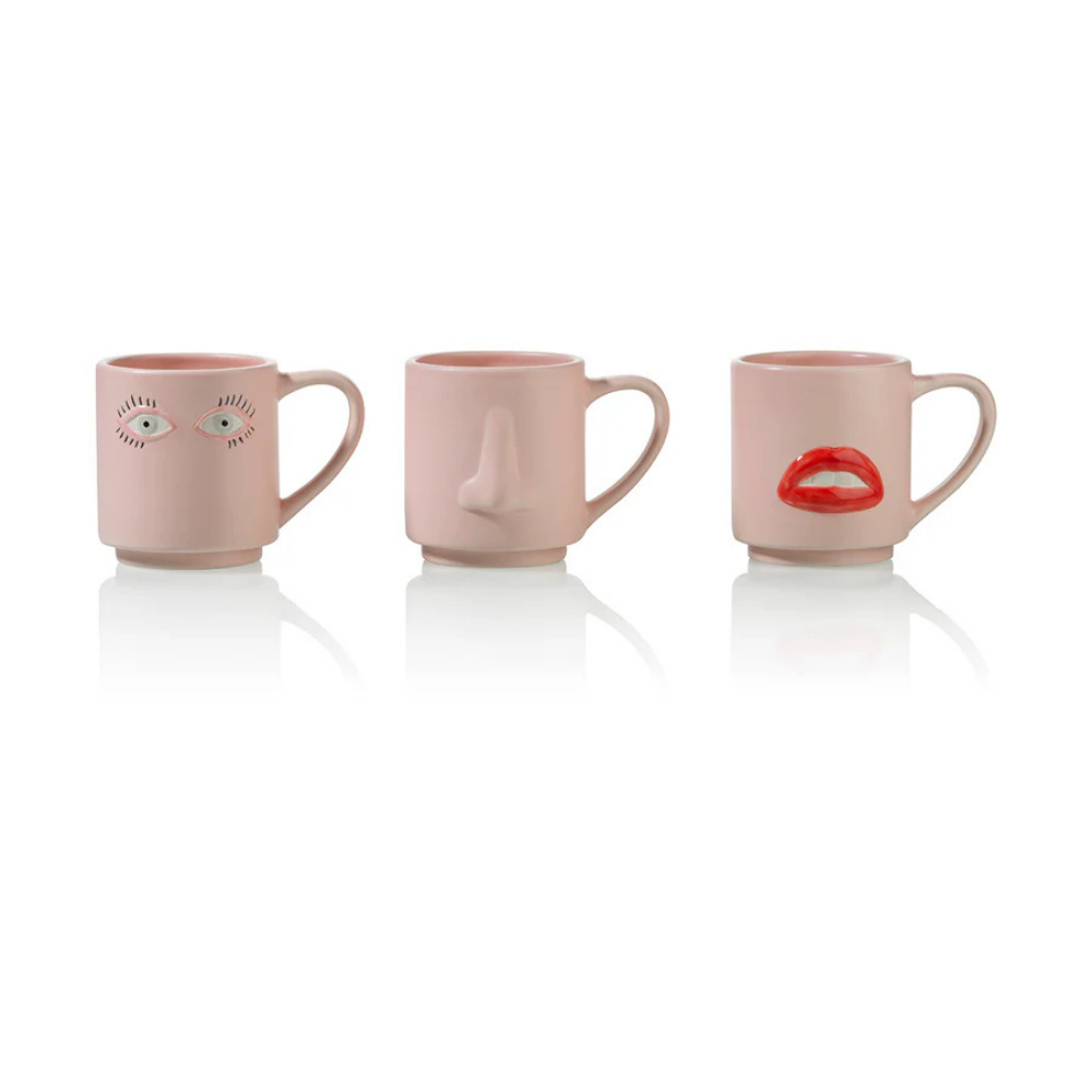 The three Surreali mugs placed side by side: the eyes one, the nose one and the lips one.