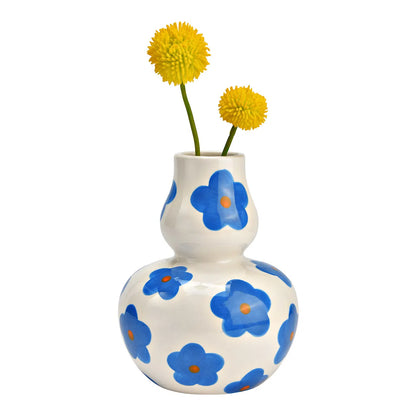 Daisy vase in white with two yellow pompom flowers placed inside.