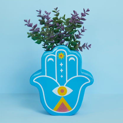 Blue Lucky Hand vase with purple leaves on a light blue background