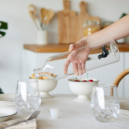 Atlantis Seal bottle held by a hand while pouring water on a table