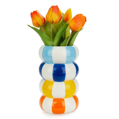 The tall striped vase holding orange tulips