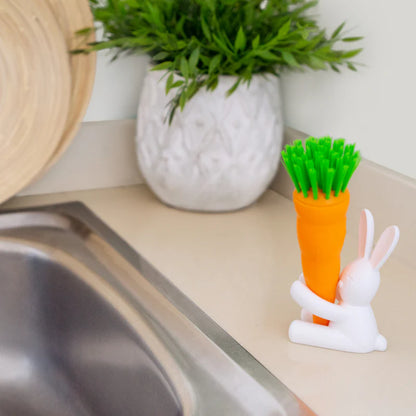 Bunny dish brush resting on a kitchen counter next to a plant