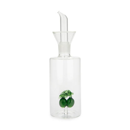 Glass oil dispenser with a pour spout and two green olives at the base
