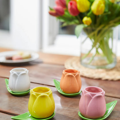 Tulip Multicolore cup set on a wooden table with a vase of tulips in the background