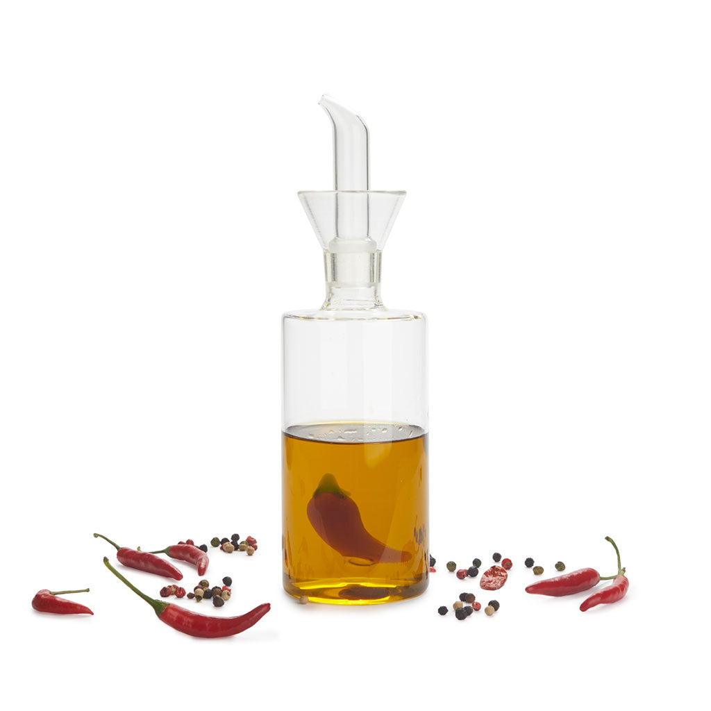Oliera Chilli: l'oliera piena d'olio circondata da peperoncini e grani di pepe.