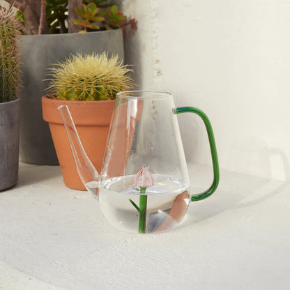 Botanical Tulip watering can with the painted pink tulip, filled with water next to a terracotta pot.