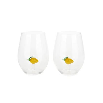 Two clear glasses each with a decorative lemon inside the glass, on white