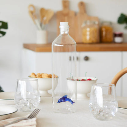 Atlantis Delfino bottle on a set table with glasses and bowls