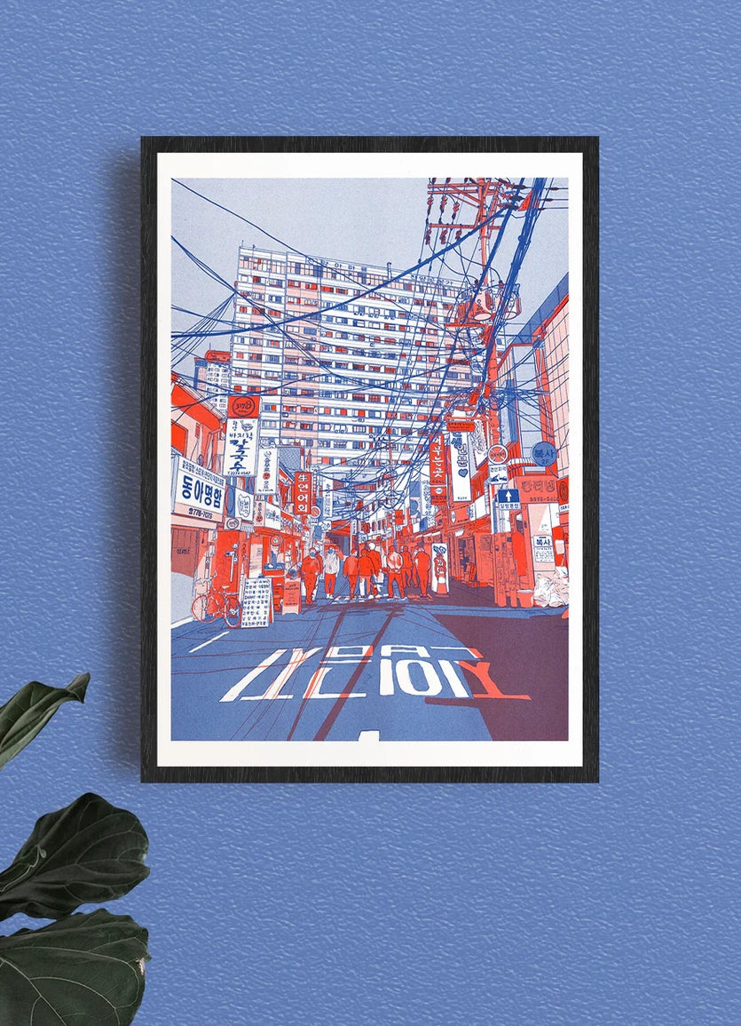 Paper Stuffing poster framed on a blue wall, a Japanese street with signs and power lines