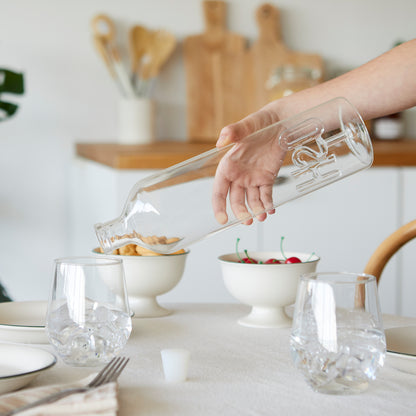 Atlantis H2O bottle held by a hand while pouring water on a table