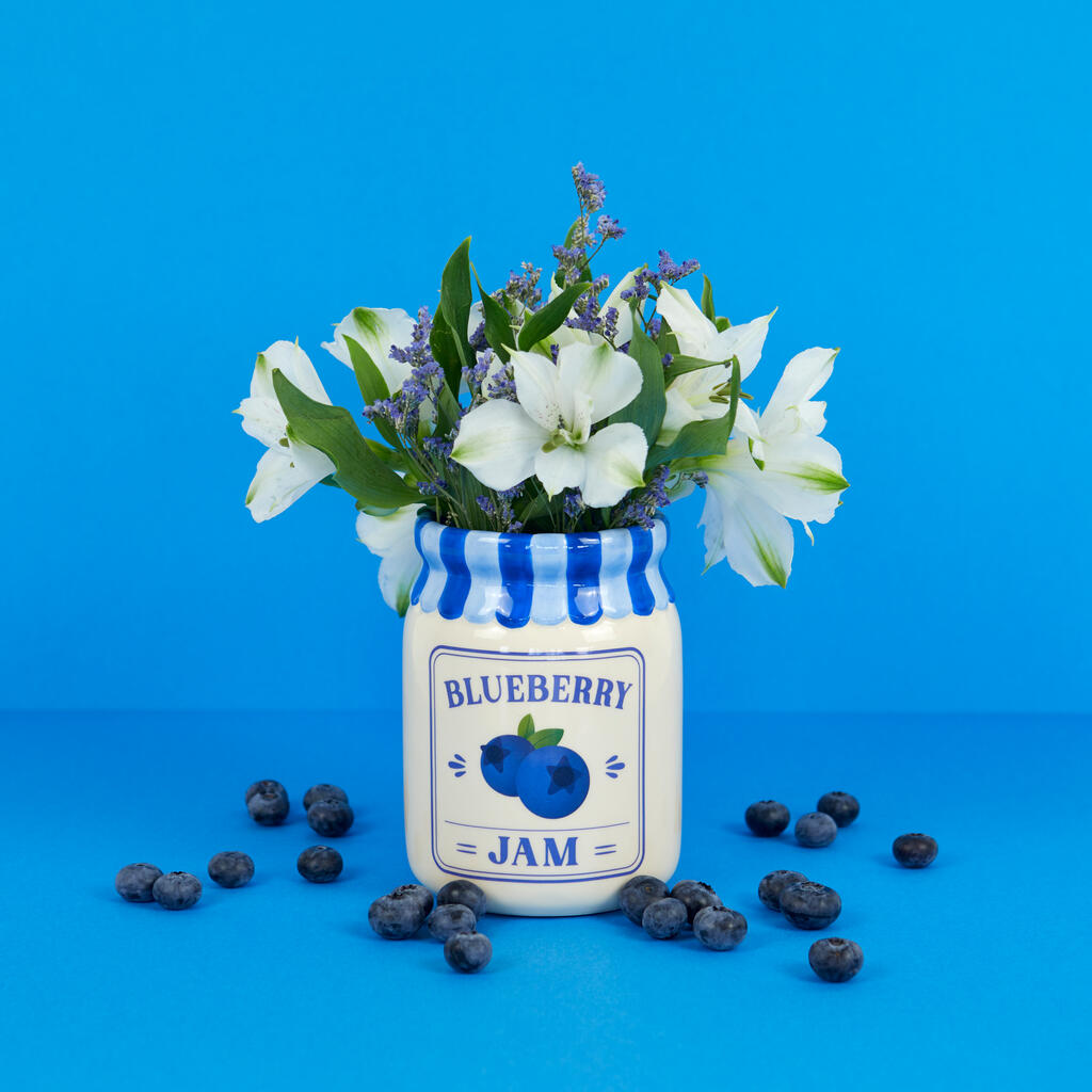 Jam vase, blueberry version with white flowers, shown from another side among blueberries