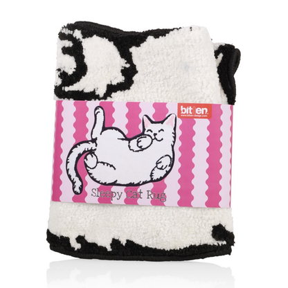 Relaxed Cat rug folded, with an illustrated tag tied around it.