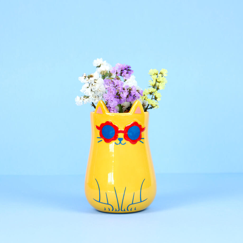 Cool Cat vase holding a bunch of flowers, on a light blue background