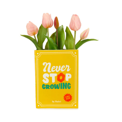 Yellow Book vase with pink tulips, close-up on a white background