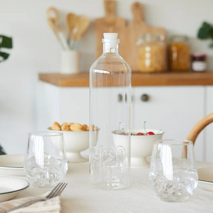 Atlantis H2O bottle on a kitchen table with bowls of biscuits and cherries