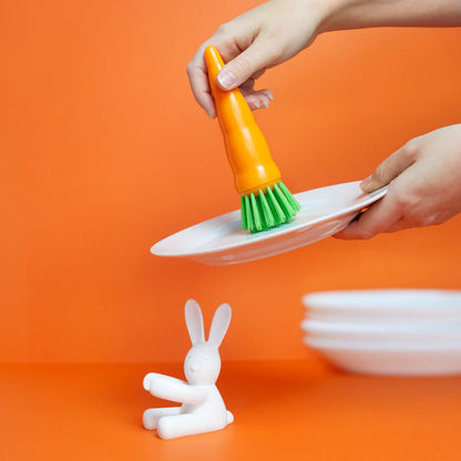 Bunny dish brush used to wash a plate above the rabbit