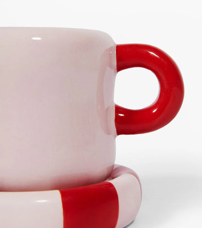 Love mug in white with a red heart-shaped handle, close-up