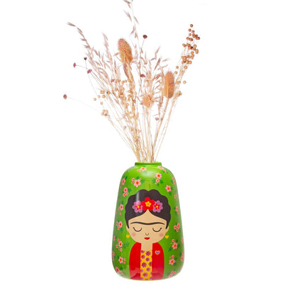 Vaso Frida Floral green vase with a painted face, filled with dried flowers on a white background.