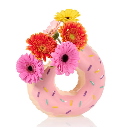 Doughnut vase in pink, styled with colourful gerberas, on a white background.