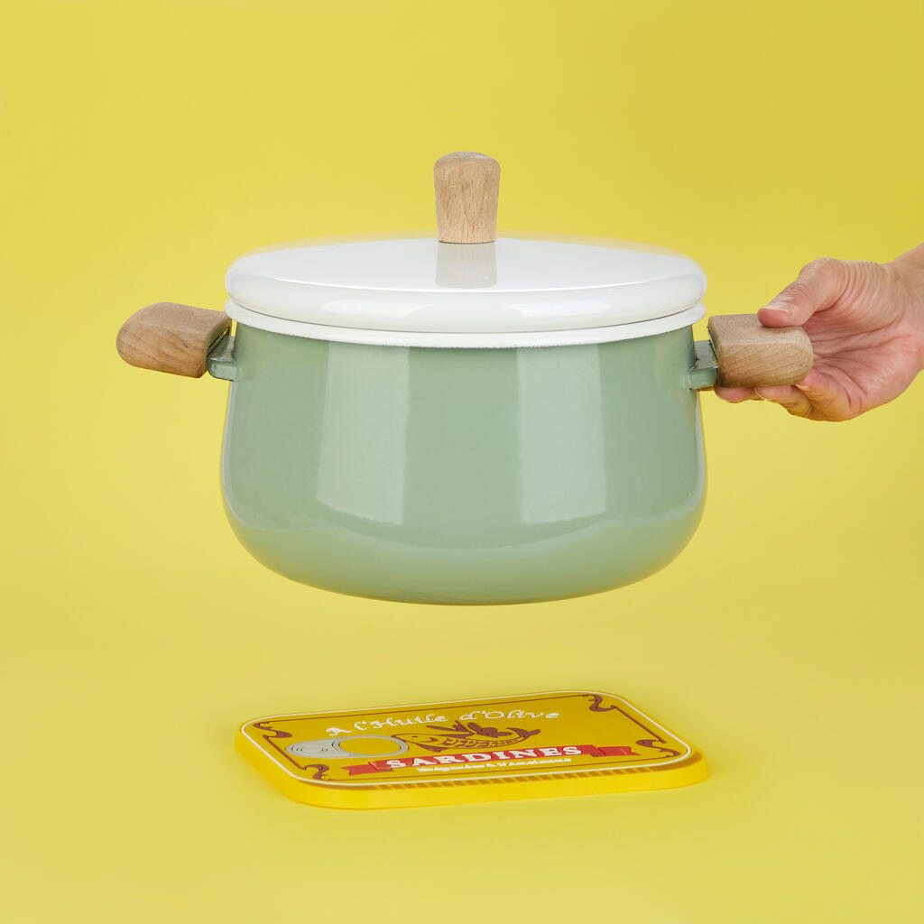 Sardines trivet placed under a green pot with wooden handles, on yellow