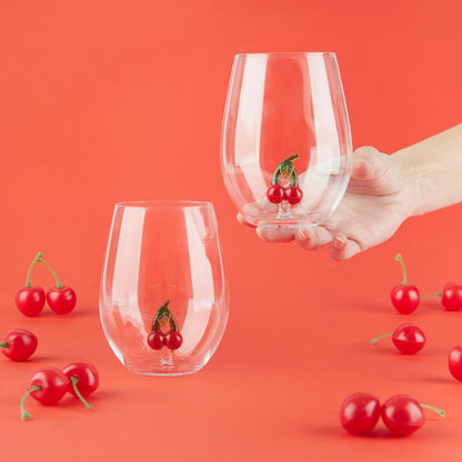 Botanical Cherry glass set, a hand lifting one glass among the scattered cherries