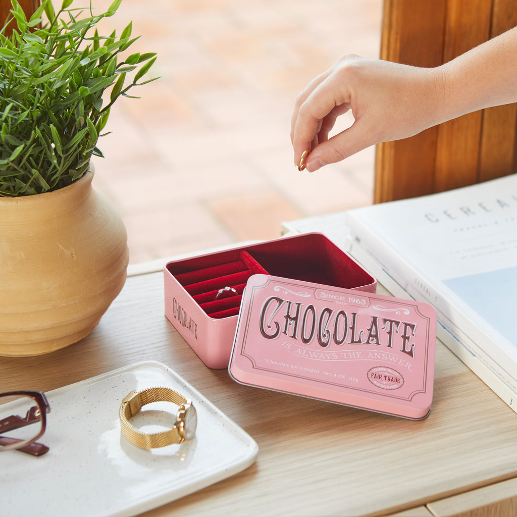 Portagioie Chocolate: una mano prende un anello dalla scatola aperta sul tavolo.