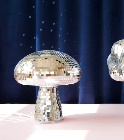 Disco mushroom lamp lit in front of a dark blue curtain
